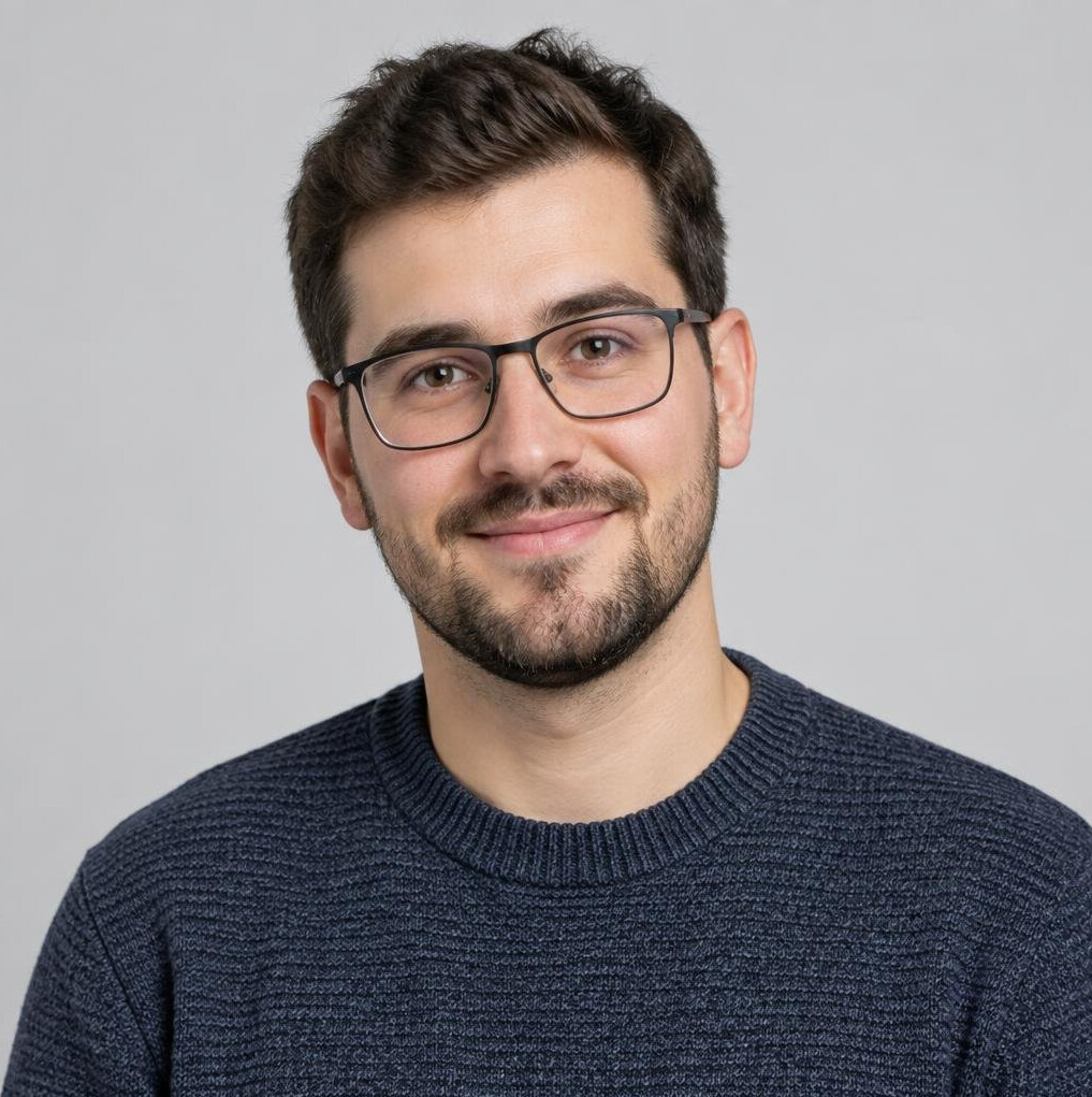Croatian man in his late 20s with glasses wearing a casual sweater, studio portrait